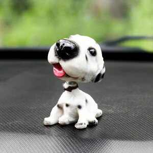 Собака на панель авто, качающая головой, далматин